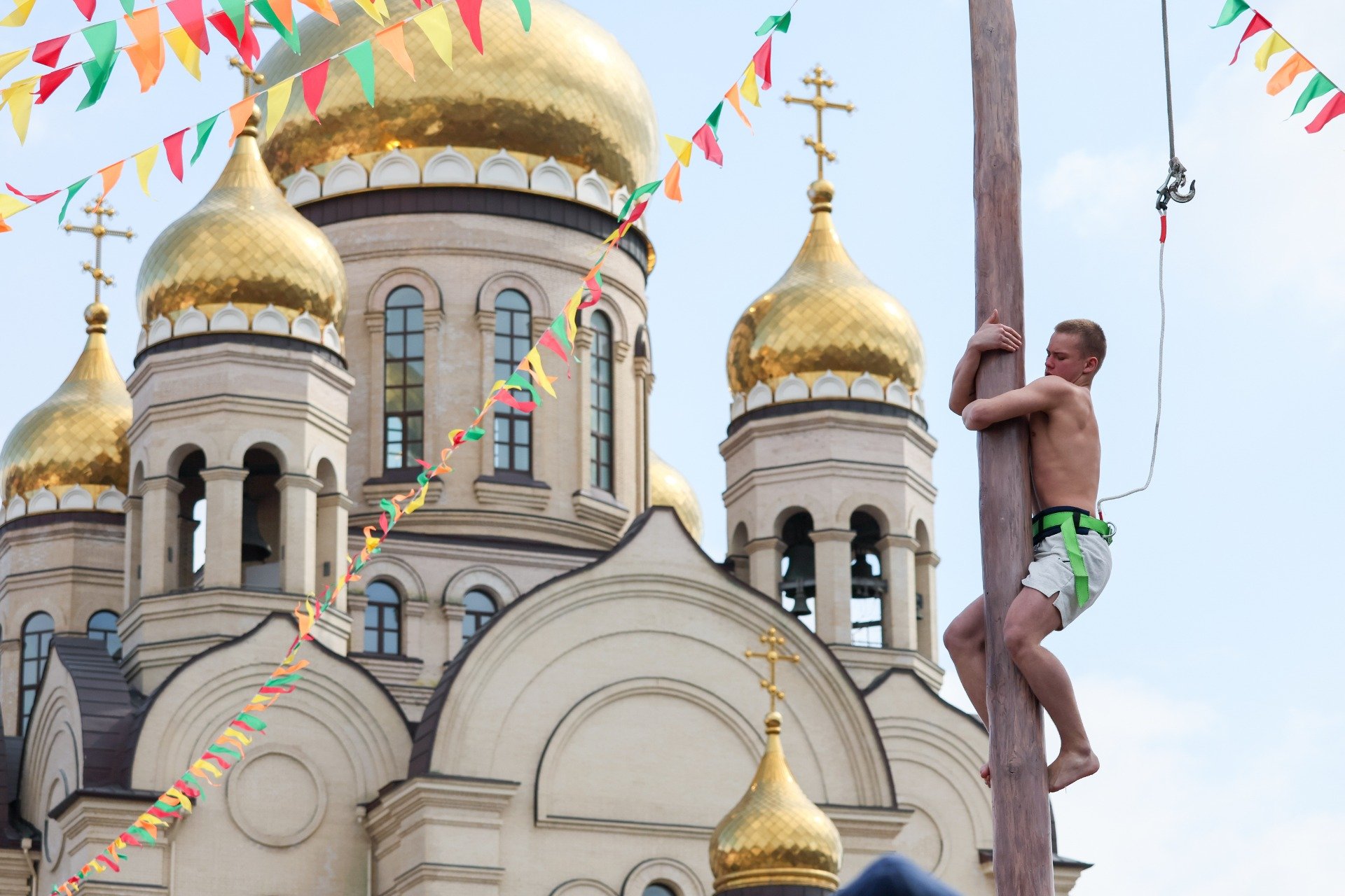 Участник народной забавы «Масленичный столб» во время масленичных гуляний. Фото: Юрий Смитюк / ТАСС